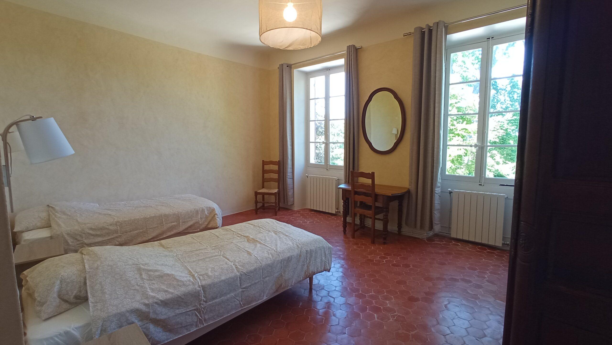 Chambre avec deux lits de la chambre 1 du domaine de Ribbe