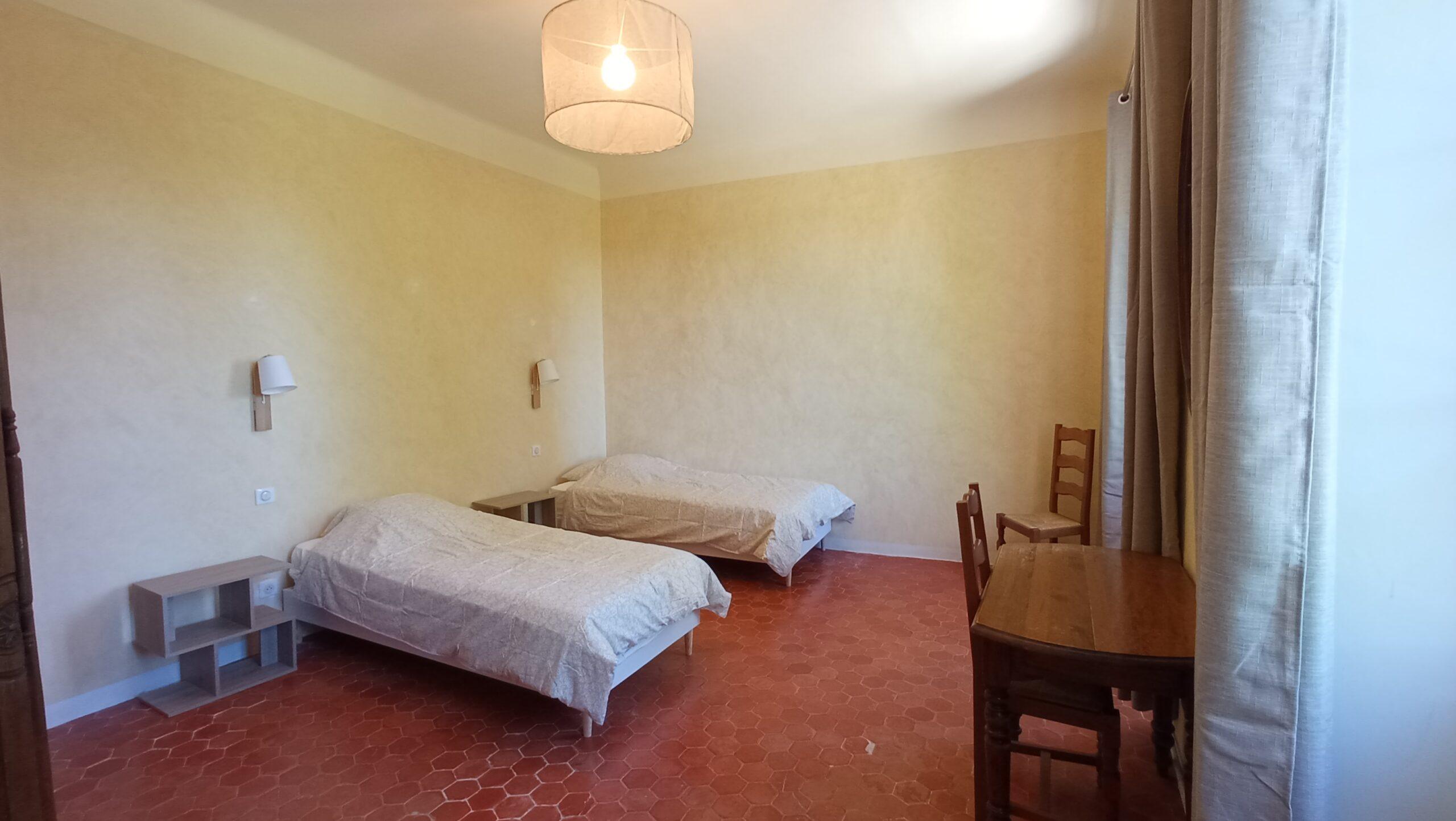 Chambre avec deux lits de la chambre 1 du domaine de Ribbe