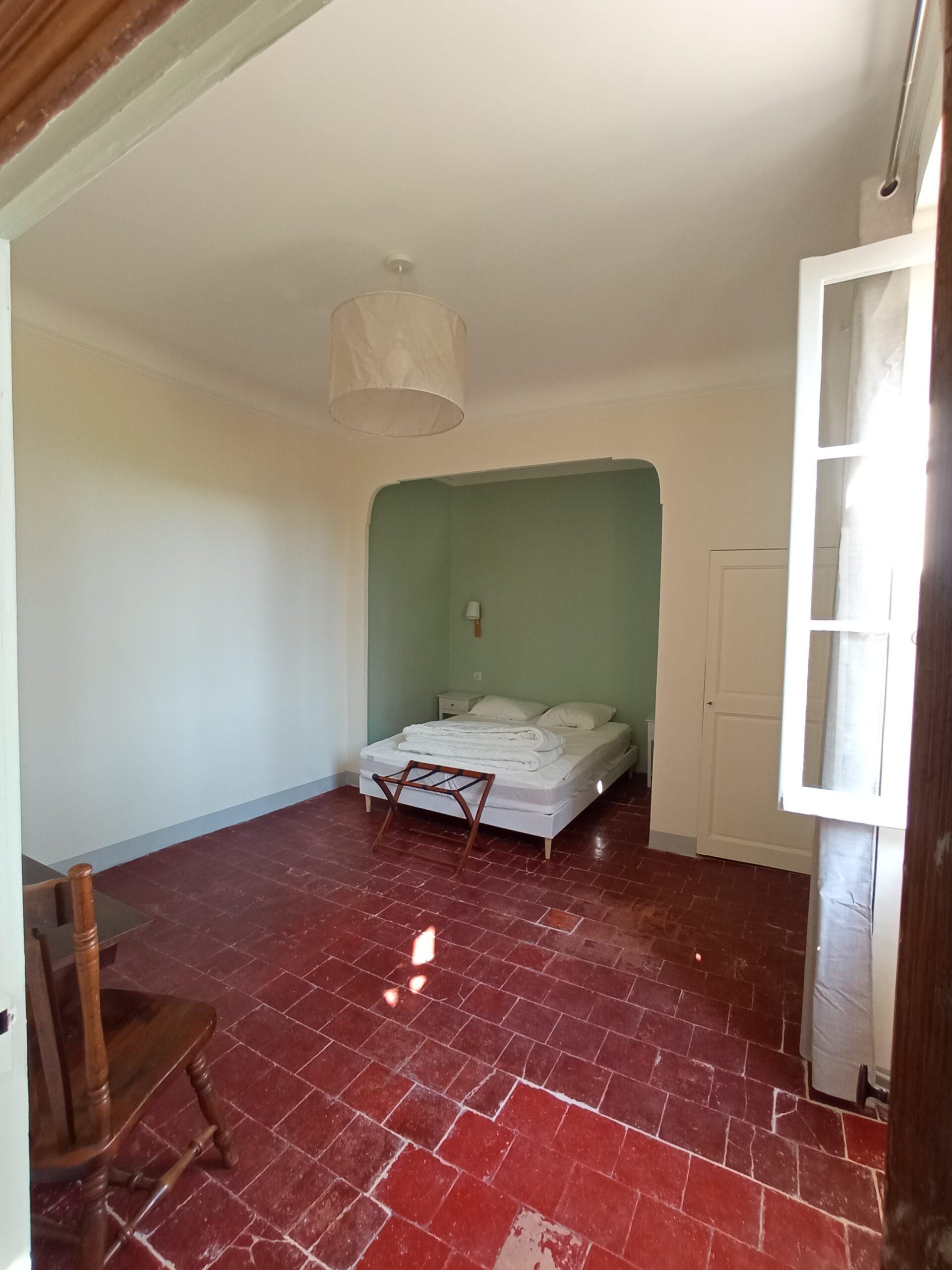 Grande chambre double avec sol en tommettes et alcôve verte du gîte de vacances au Domaine de Ribbe