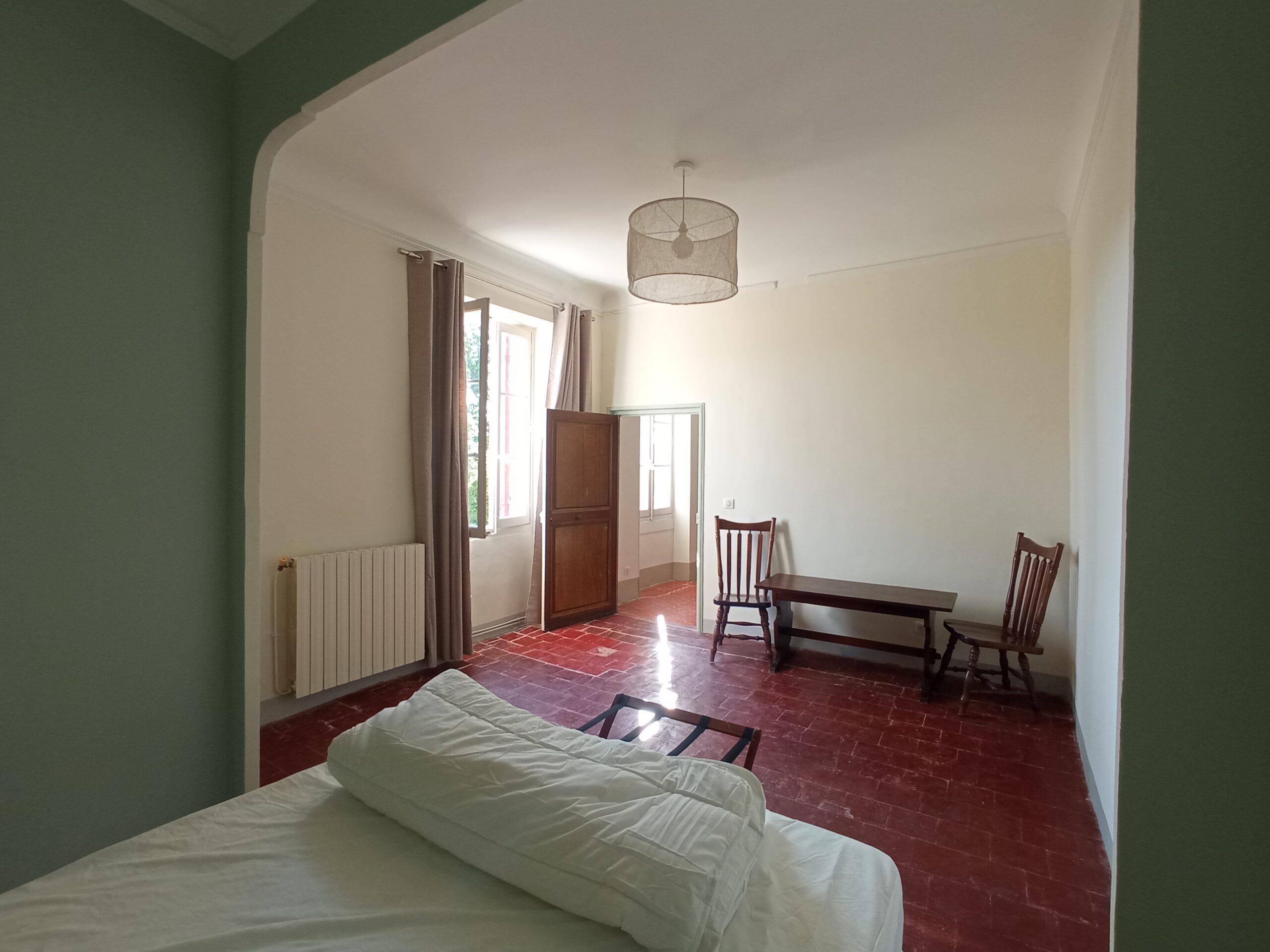 Vue depuis le lit de la chambre 5 du gîte montrant l'espace de la pièce et le sol en tommettes