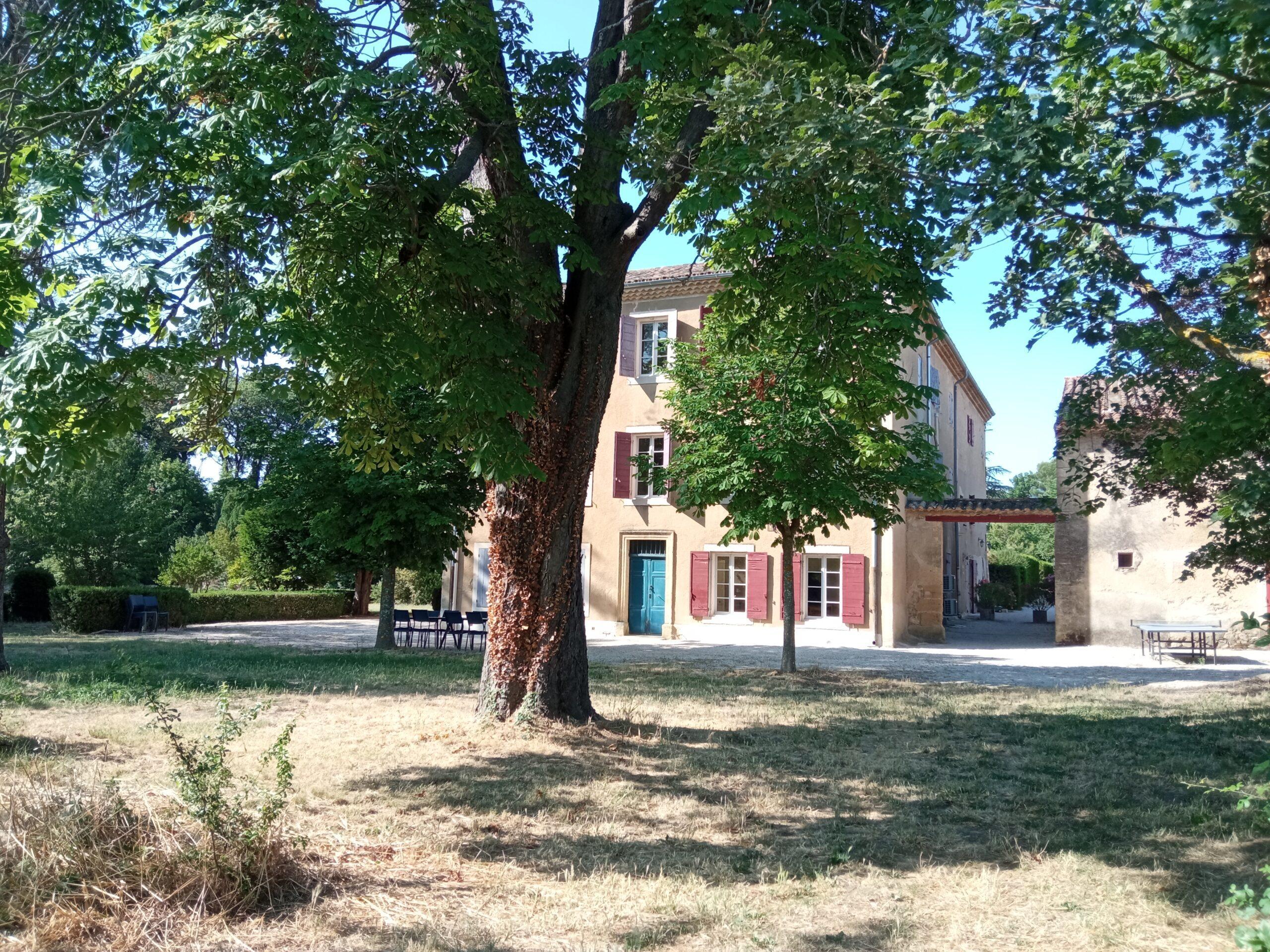 Vue extérieure de la façade principale de la bastide du Domaine de Ribbe avec ses nombreux volets et sa cour gravillonnée.