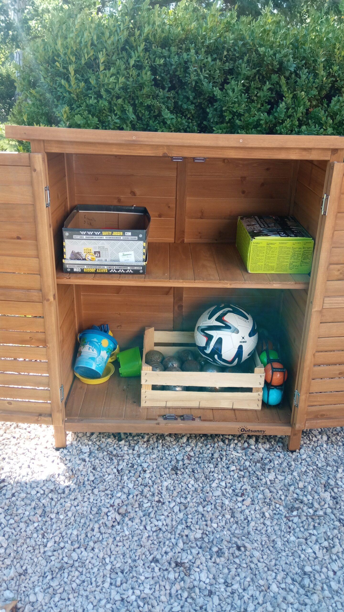 Armoire de rangement en bois contenant des jeux d'extérieur pour les clients du Domaine de Ribbe