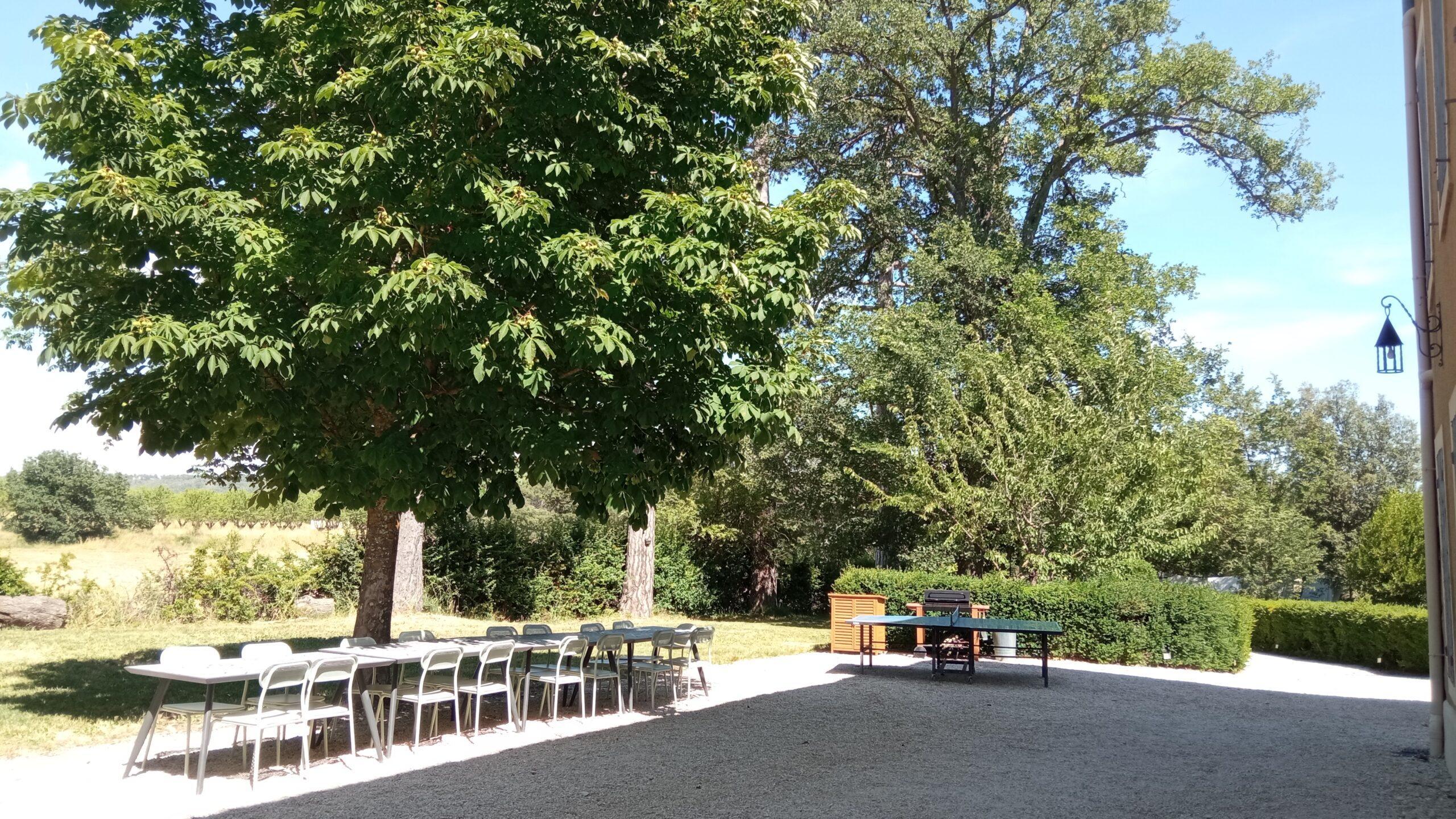 Grande table de jardin ombragée et table de ping-pong au Domaine de Ribbe