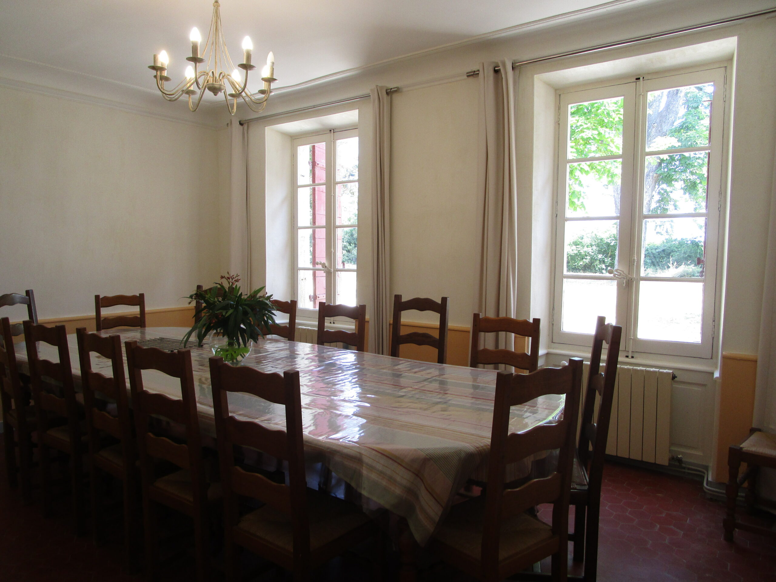Grande salle à manger avec longue table réservée aux locataires du gîte au Domaine de Ribbe