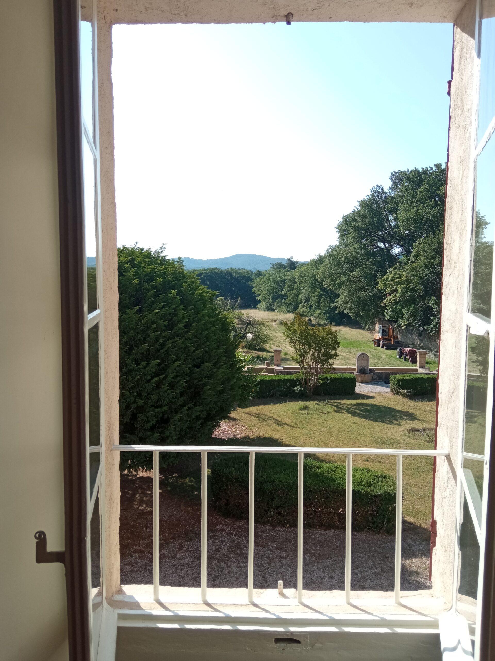 Vue ensoleillée depuis la fenêtre de la chambre 3 sur le parc verdoyant du Domaine de Ribbe